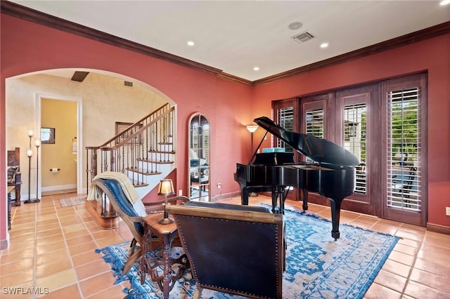 living area with arched walkways, visible vents, ornamental molding, light tile patterned flooring, and baseboards