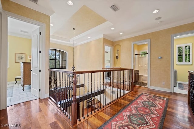 hall featuring recessed lighting, wood finished floors, visible vents, baseboards, and crown molding