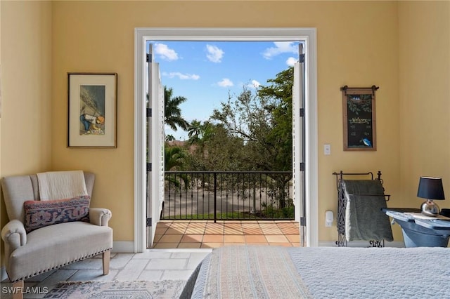 bedroom with access to outside and baseboards