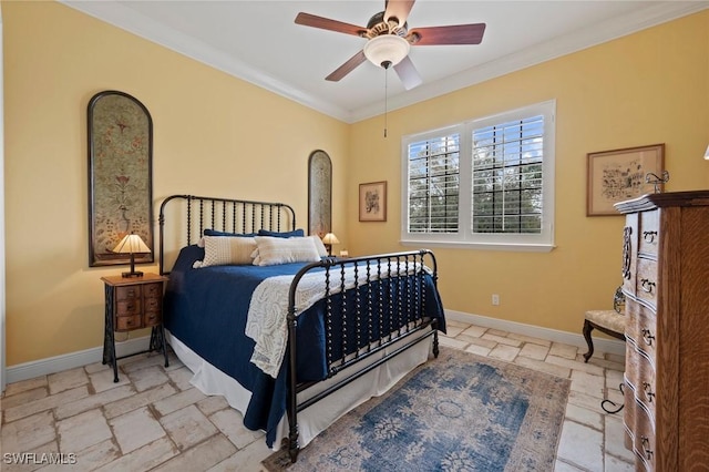 bedroom featuring stone tile floors, ornamental molding, ceiling fan, and baseboards