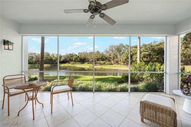 sunroom / solarium featuring a ceiling fan and a water view