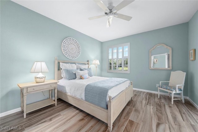 bedroom featuring ceiling fan, baseboards, and wood finished floors