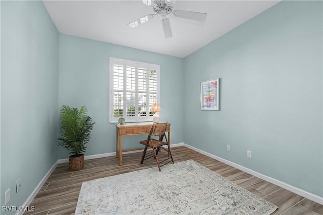 home office with a ceiling fan, baseboards, and wood finished floors