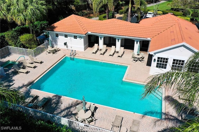 community pool featuring fence and a patio