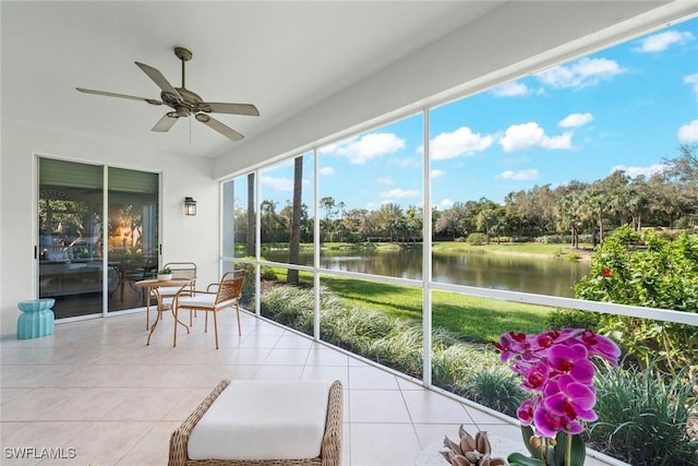 sunroom / solarium featuring a water view and a ceiling fan