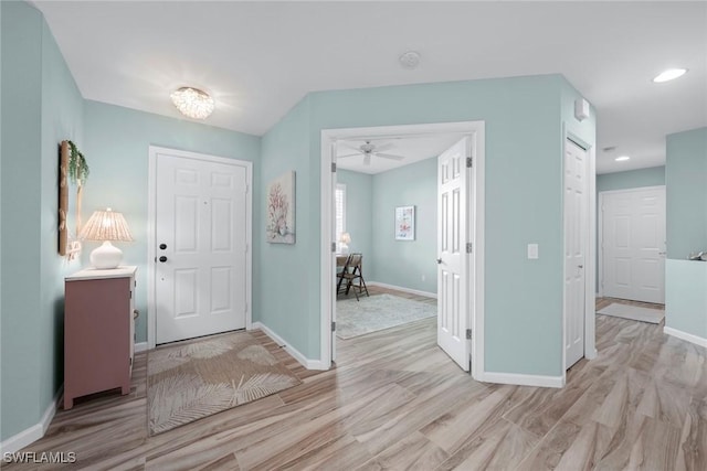 foyer entrance with light wood finished floors, recessed lighting, and baseboards