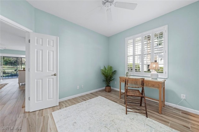 home office featuring ceiling fan, baseboards, and wood finished floors