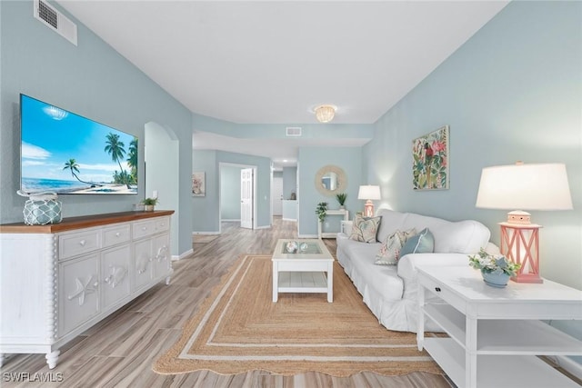 living area featuring light wood-style floors, baseboards, and visible vents