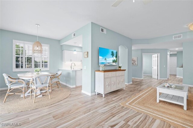 interior space with white cabinetry, a sink, visible vents, and baseboards