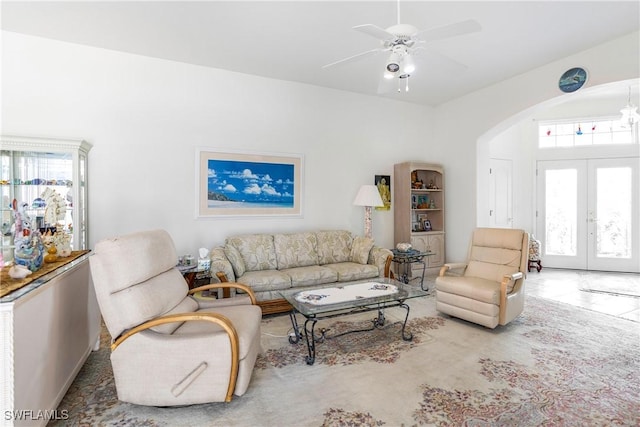 living room with arched walkways, a ceiling fan, and french doors