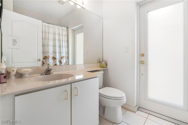 bathroom with visible vents, toilet, vanity, and tile patterned floors