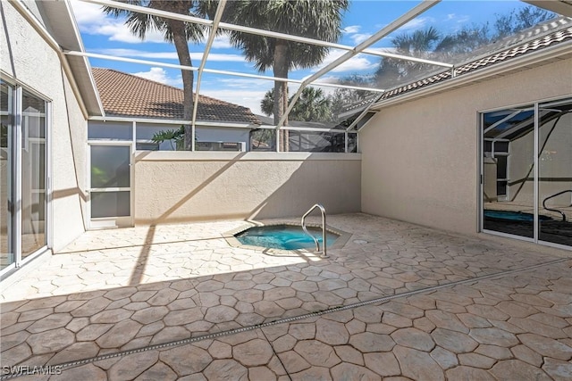 view of swimming pool with a patio, glass enclosure, and an in ground hot tub