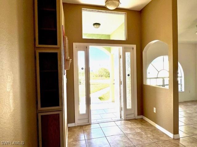 foyer entrance with light tile patterned floors and baseboards