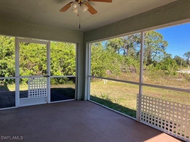 unfurnished sunroom with a ceiling fan