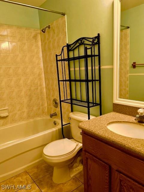 bathroom with toilet, shower / bathtub combination, vanity, and tile patterned floors