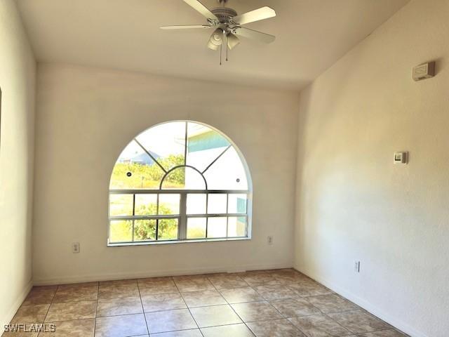 unfurnished room featuring a ceiling fan and light tile patterned flooring