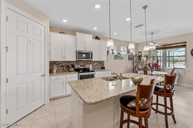 4178 Bloomfield St, Fort Myers, FL 33916 - kitchen with appliances with stainless steel finishes, a sink, light tile patterned flooring, backsplash, and a breakfast bar