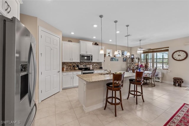 4178 Bloomfield St, Fort Myers, FL 33916 - kitchen featuring appliances with stainless steel finishes, a sink, tasteful backsplash, white cabinetry, and a kitchen breakfast bar