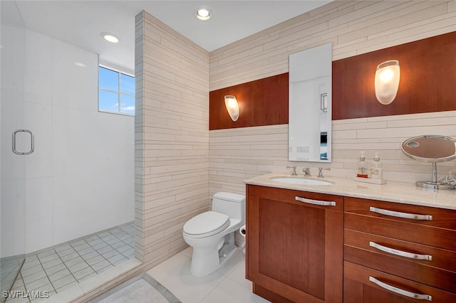 full bath with a stall shower, tile walls, toilet, and vanity