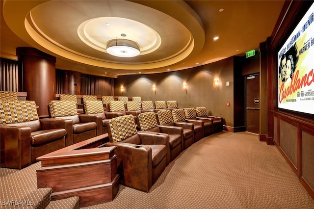 home theater room with a tray ceiling, light colored carpet, and recessed lighting