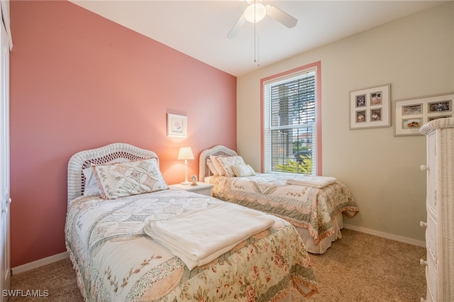 bedroom with light carpet, baseboards, and a ceiling fan