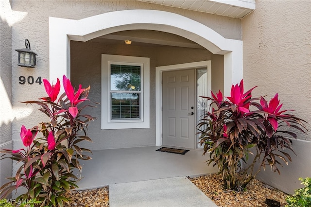 property entrance with stucco siding