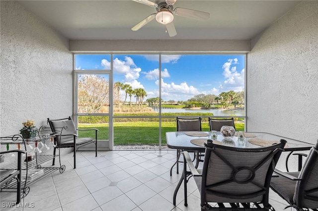 sunroom with a water view and a ceiling fan