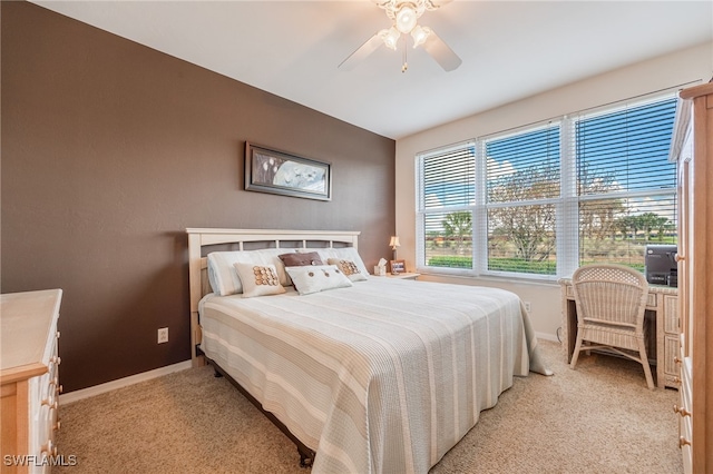 bedroom featuring baseboards, a ceiling fan, and light colored carpet