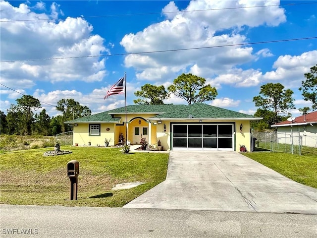 ranch-style home featuring driveway, an attached garage, fence, a front yard, and stucco siding