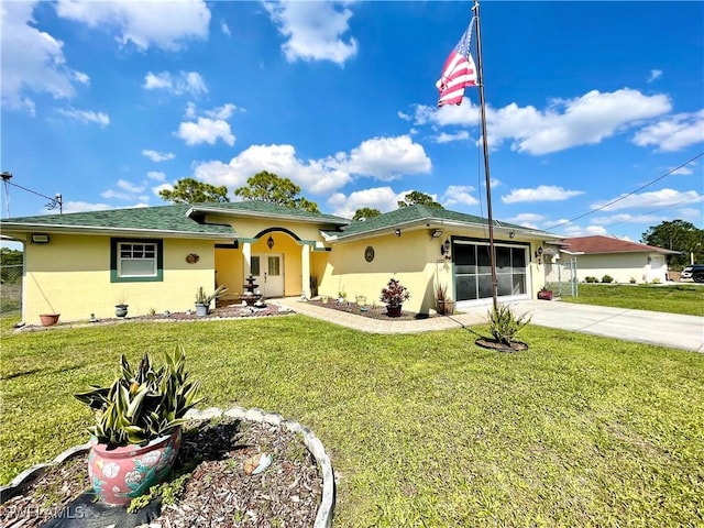 ranch-style home with a garage, driveway, a front lawn, and stucco siding