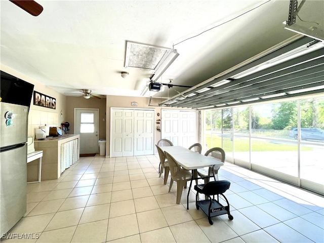 dining space with a ceiling fan and light tile patterned floors