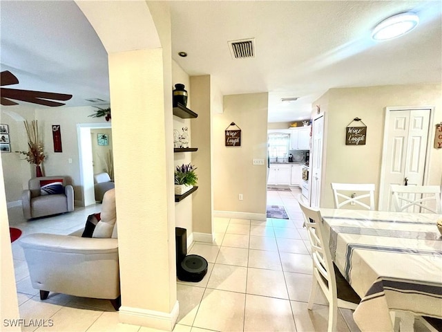 corridor featuring light tile patterned floors, visible vents, and baseboards