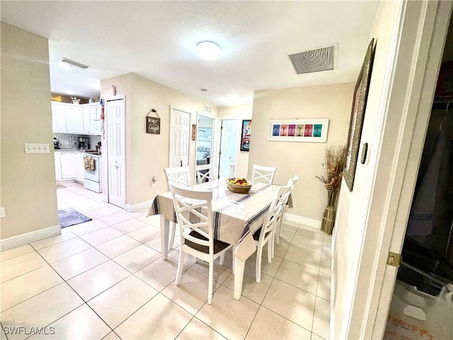 dining space with visible vents, baseboards, and light tile patterned flooring