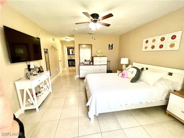 bedroom with a ceiling fan, baseboards, and light tile patterned floors