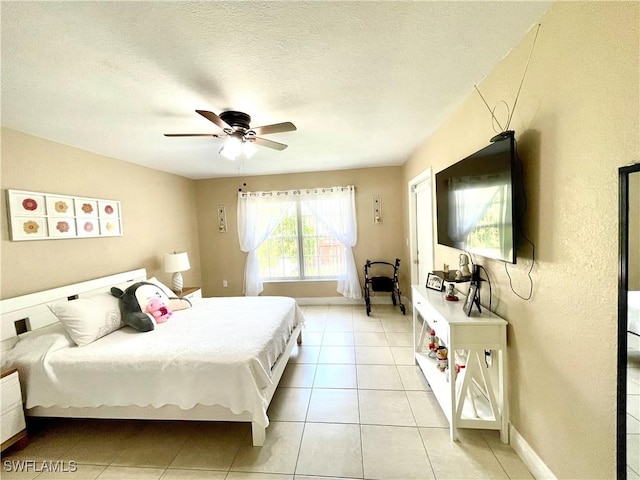 bedroom with light tile patterned floors, ceiling fan, a textured ceiling, and baseboards