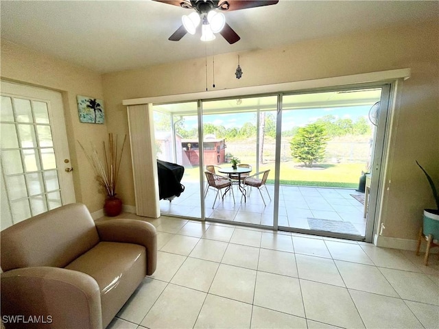 doorway featuring light tile patterned floors, baseboards, and a ceiling fan