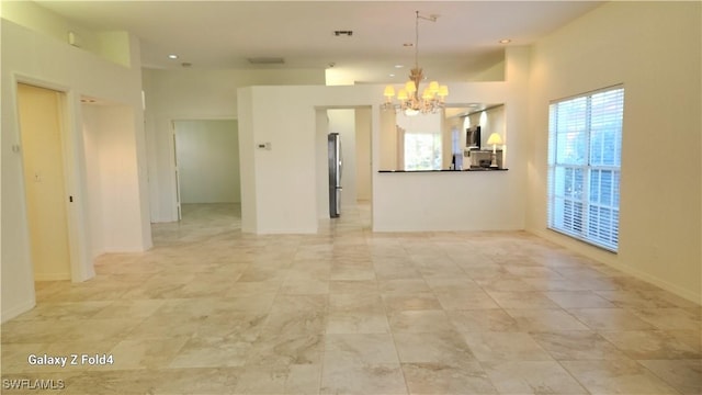 spare room with baseboards, visible vents, and an inviting chandelier