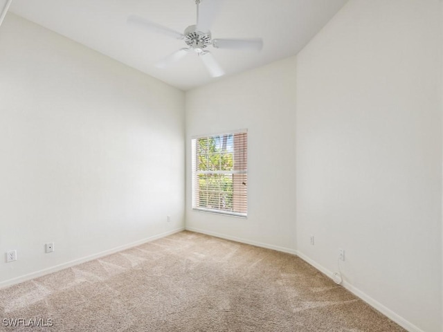 unfurnished room with baseboards, a ceiling fan, and light colored carpet