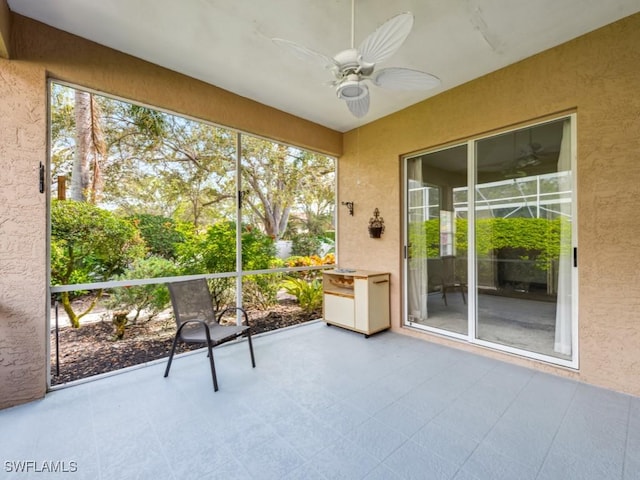 unfurnished sunroom with a wealth of natural light and ceiling fan