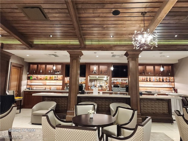 bar featuring light tile patterned flooring, decorative light fixtures, and ornate columns