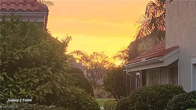 view of side of property featuring a tile roof