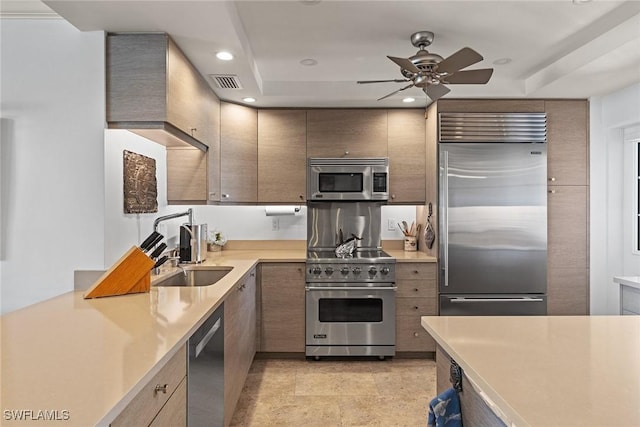 kitchen with recessed lighting, light countertops, visible vents, a sink, and high quality appliances