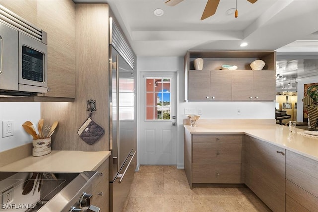 kitchen featuring ceiling fan, appliances with stainless steel finishes, a tray ceiling, light countertops, and open shelves