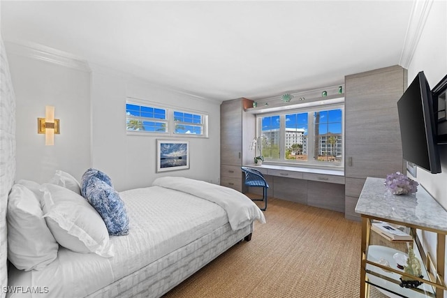 bedroom with ornamental molding and built in desk