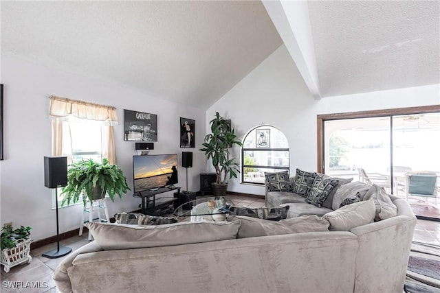 living area with tile patterned flooring, vaulted ceiling, and a textured ceiling