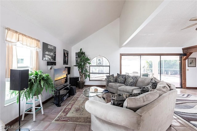 living room featuring vaulted ceiling, ceiling fan, a wealth of natural light, and baseboards