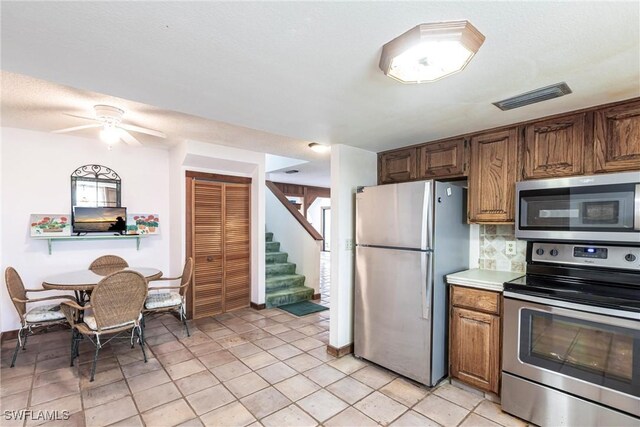 kitchen with visible vents, decorative backsplash, a ceiling fan, appliances with stainless steel finishes, and light countertops