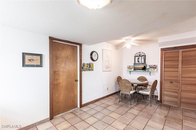 dining room featuring ceiling fan, baseboards, and a textured ceiling