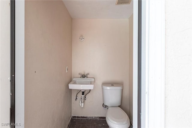 bathroom featuring visible vents, a sink, and toilet