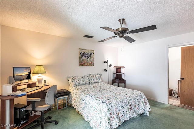 carpeted bedroom featuring a textured ceiling, visible vents, and a ceiling fan